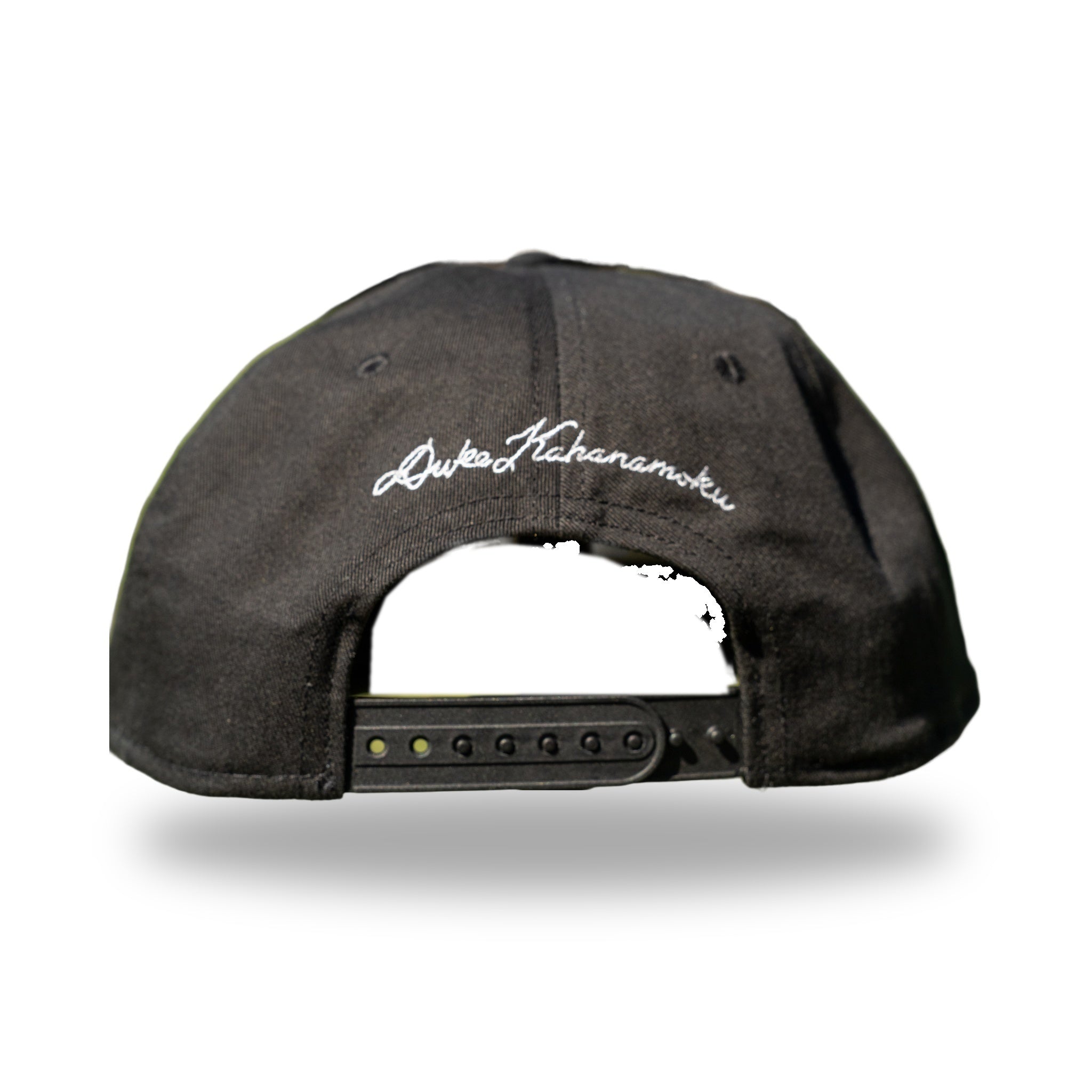 Back of black snapback with white Duke Kahanamoku signature embroidery above snap closure