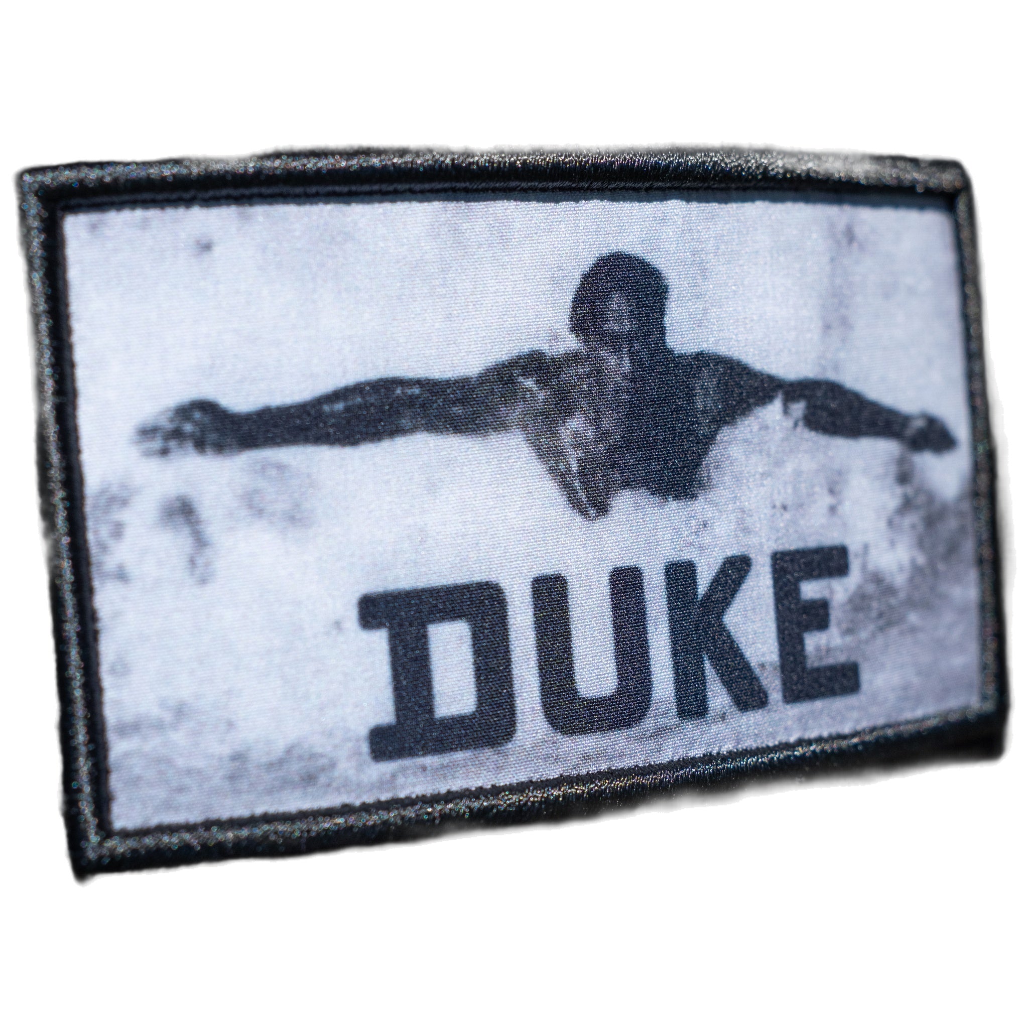 Close-up of woven swimmer photo patch with DUKE lettering on black cap