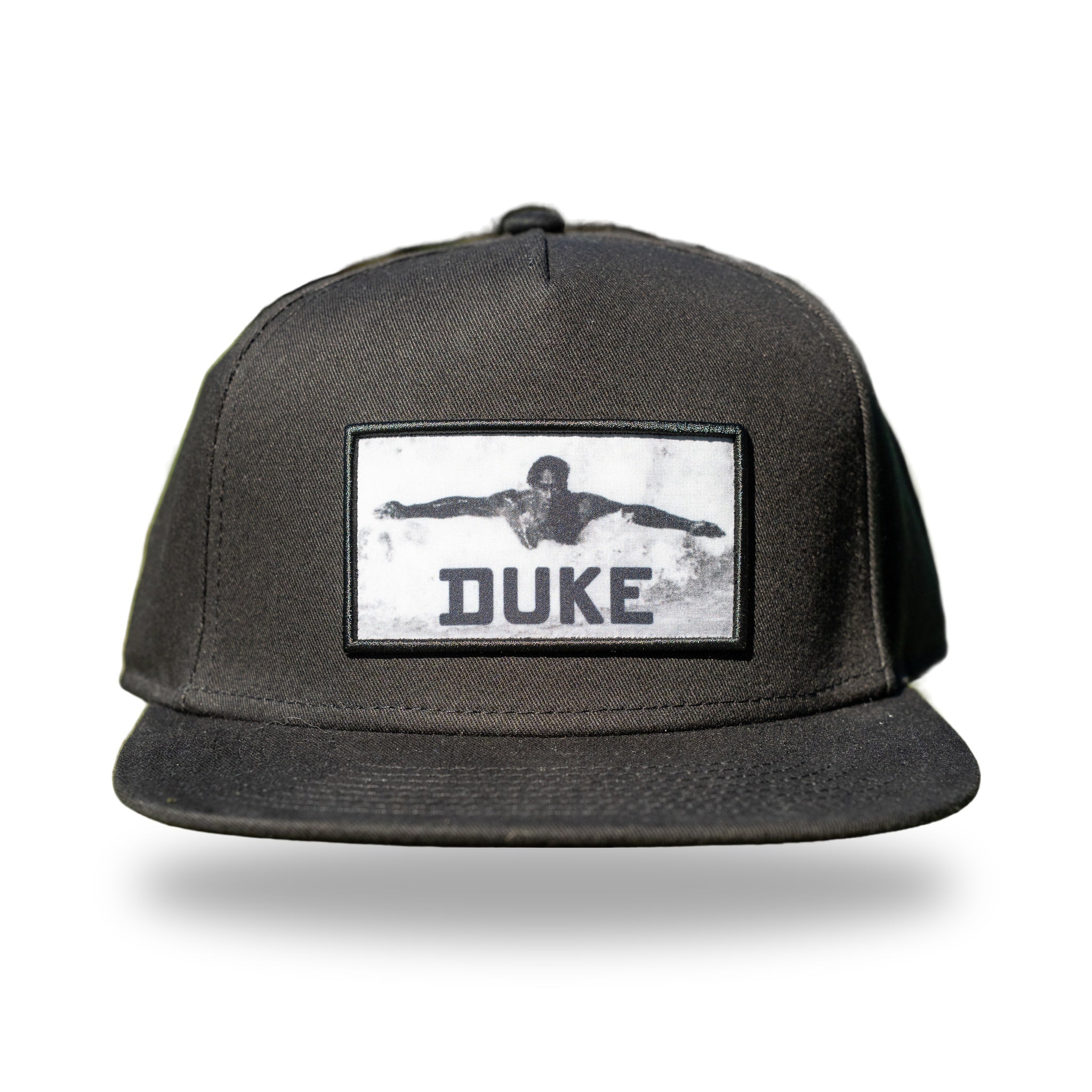 Black flat-brim snapback with woven black and white photo patch of Duke Kahanamoku swimming