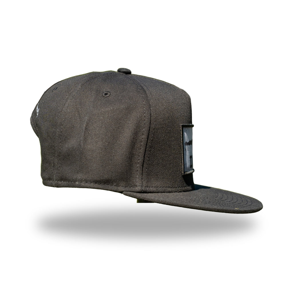 Side profile of black DUKE photo patch snapback