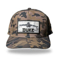 Camo flat-brim snapback with woven photo patch of Duke Kahanamoku swimming and raised 3D black DUKE lettering