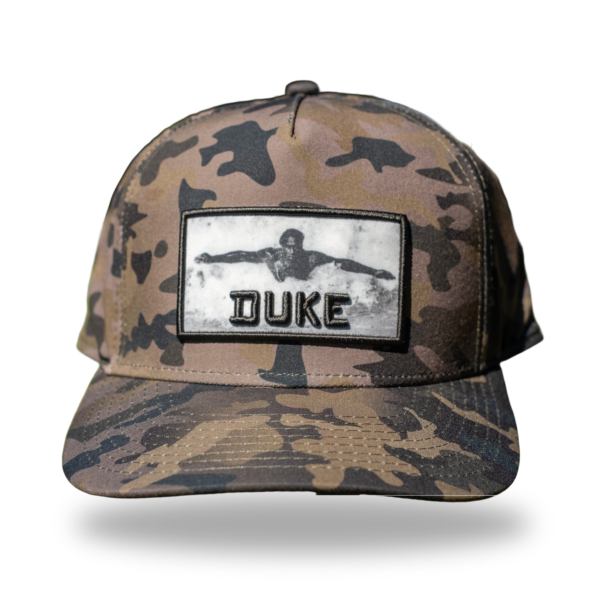 Camo flat-brim snapback with woven photo patch of Duke Kahanamoku swimming and raised 3D black DUKE lettering