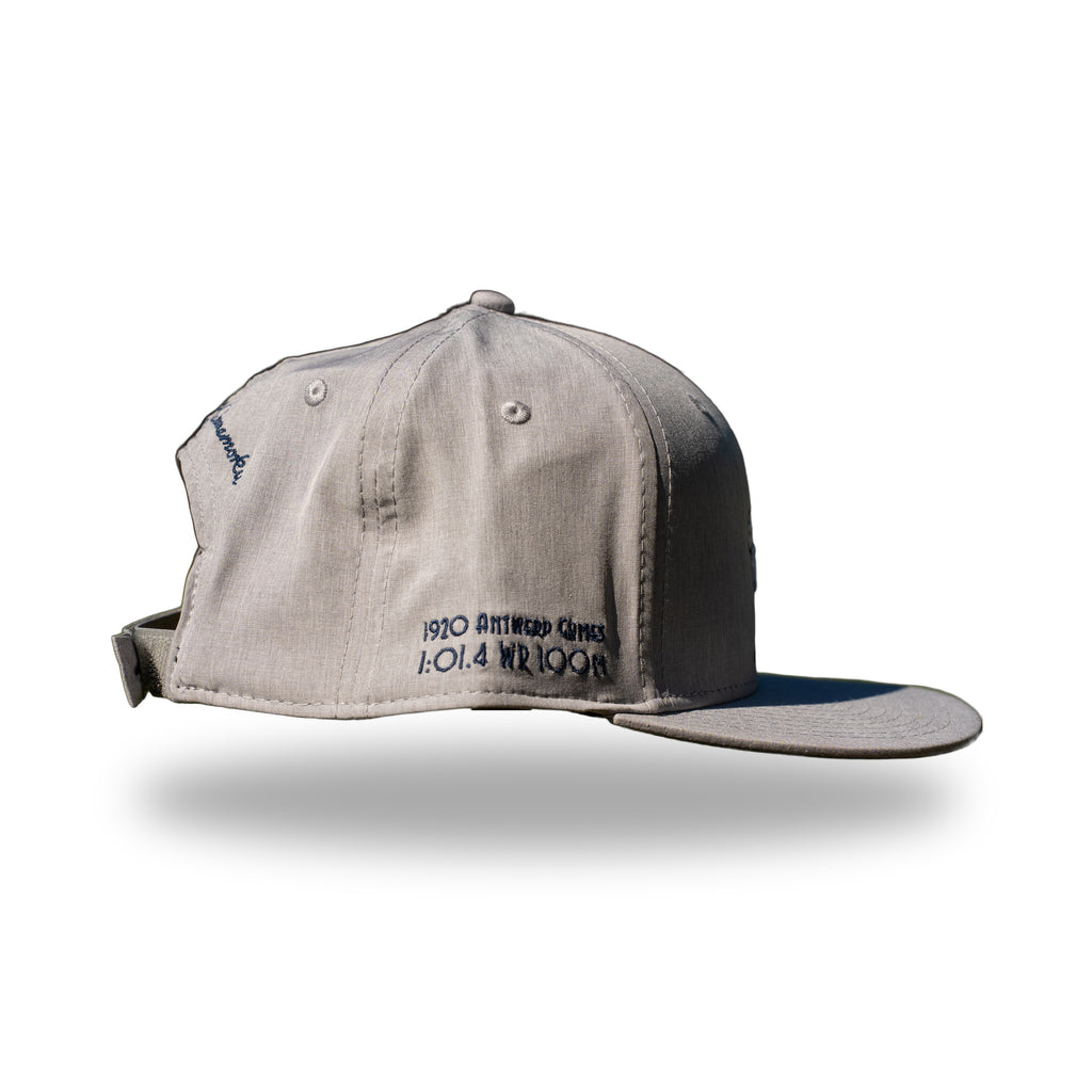 Side of heather gray DUKE cap showing 1920 Antwerp Games 1:01.4 WR 100M embroidery