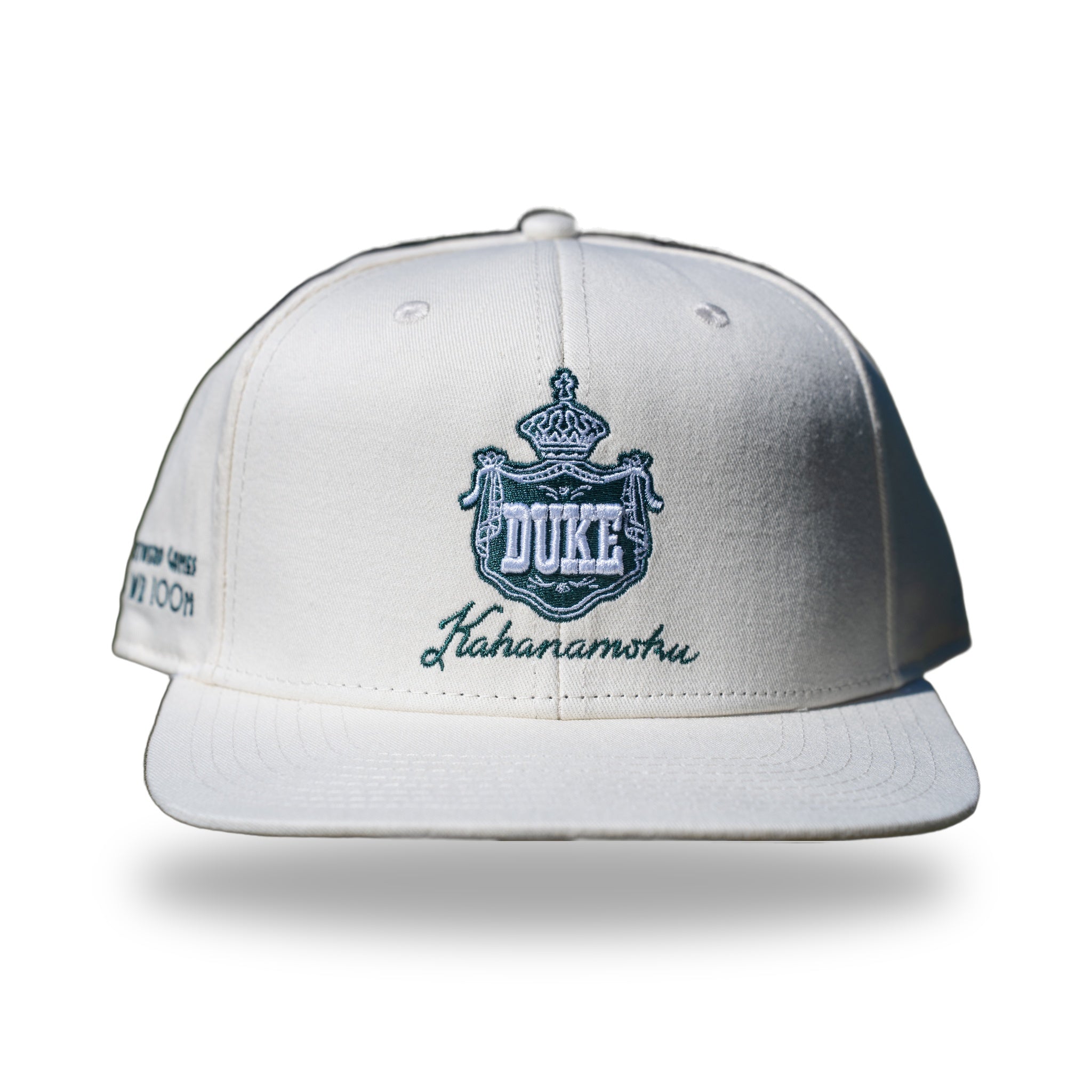 Ivory snapback cap with teal embroidered Hawaiian royal crest reading DUKE and Kahanamoku script